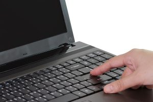 Closeup of business woman typing on laptop keyboard